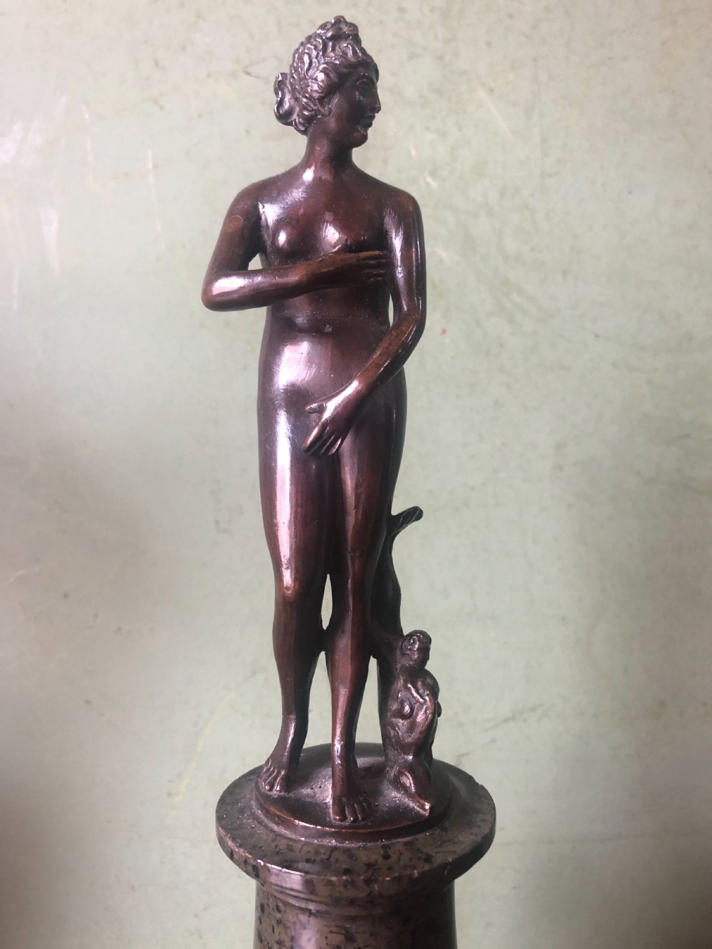 A pair of late nineteenth-century dark patinated bronze classical nude figures mounted on tall cylindrical dark marble column bases. View VII