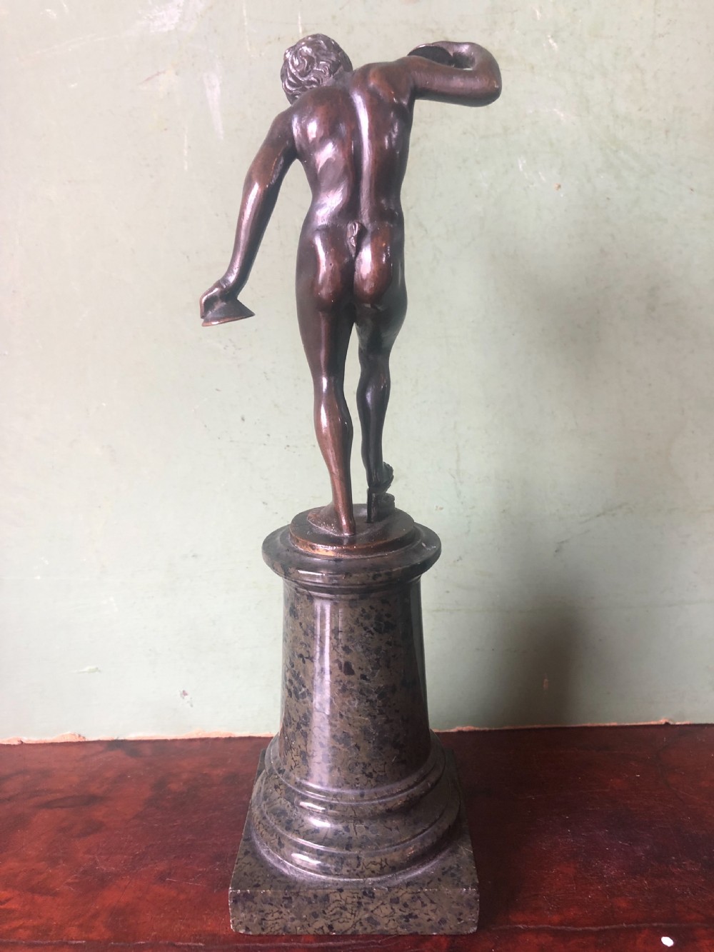 A pair of late nineteenth-century dark patinated bronze classical nude figures mounted on tall cylindrical dark marble column bases. View VIII