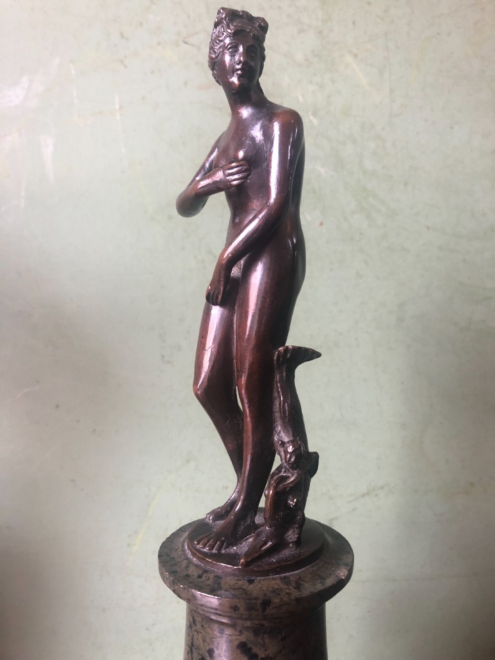 A pair of late nineteenth-century dark patinated bronze classical nude figures mounted on tall cylindrical dark marble column bases. View X