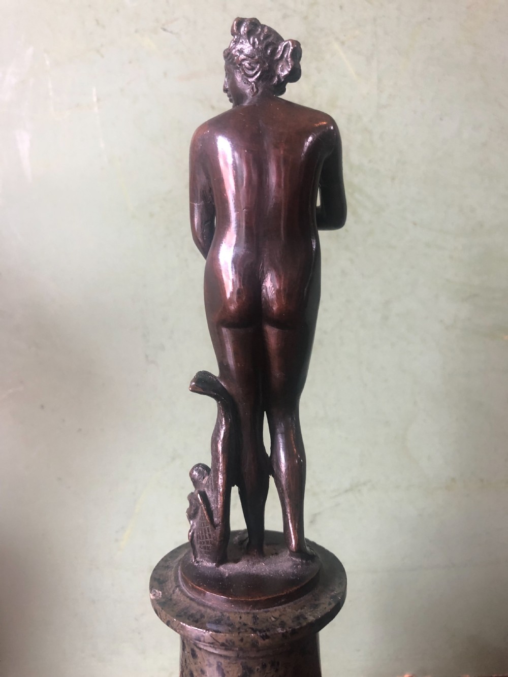 A pair of late nineteenth-century dark patinated bronze classical nude figures mounted on tall cylindrical dark marble column bases. View XII