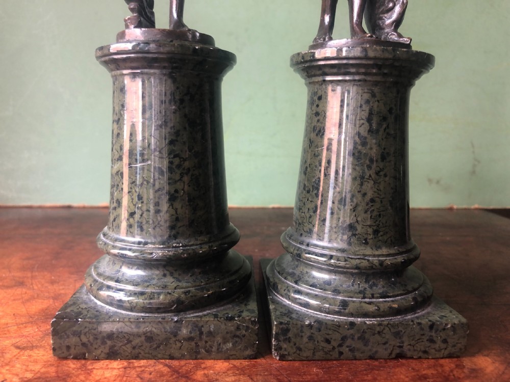 A pair of late nineteenth-century dark patinated bronze classical nude figures mounted on tall cylindrical dark marble column bases. View XVIII