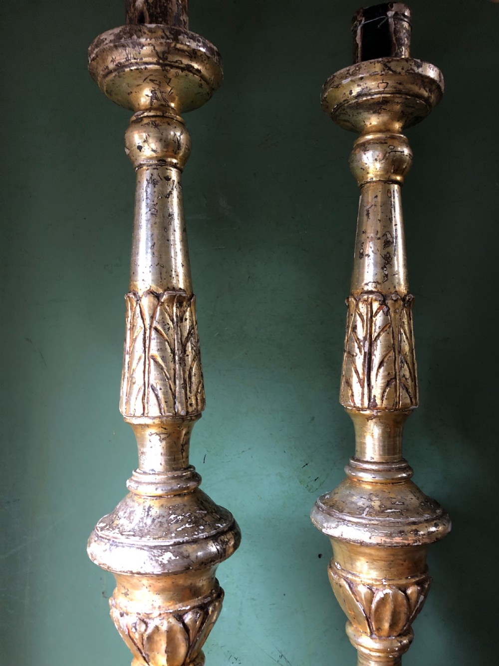 A pair of tall late eighteenth-century Italian carved giltwood altar candlesticks with turned baluster stems and mecca finish. View XVII