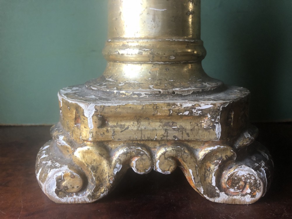 A pair of tall late eighteenth-century Italian carved giltwood altar candlesticks with turned baluster stems and mecca finish. View XVIII