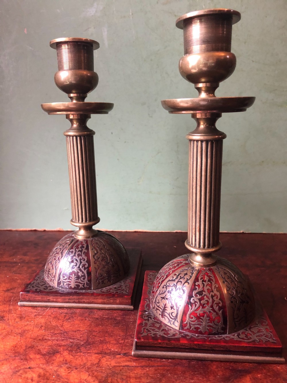 A pair of late 19th-century brass candlesticks featuring fluted columns supported by domed square bases inlaid with red tortoiseshell and engraved brass Boulle-work scroll motifs. View IV
