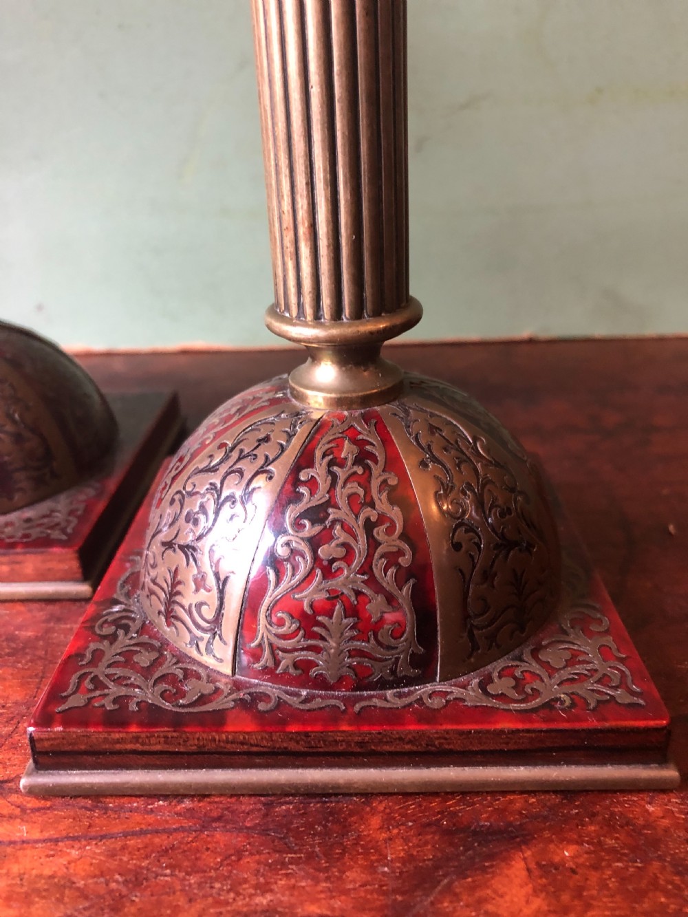 A pair of late 19th-century brass candlesticks featuring fluted columns supported by domed square bases inlaid with red tortoiseshell and engraved brass Boulle-work scroll motifs. View V