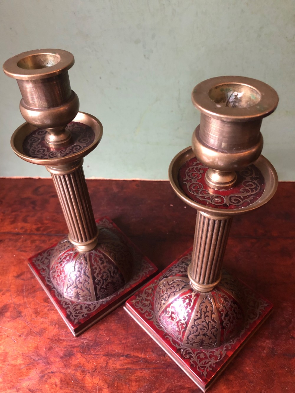 A pair of late 19th-century brass candlesticks featuring fluted columns supported by domed square bases inlaid with red tortoiseshell and engraved brass Boulle-work scroll motifs. View VIII