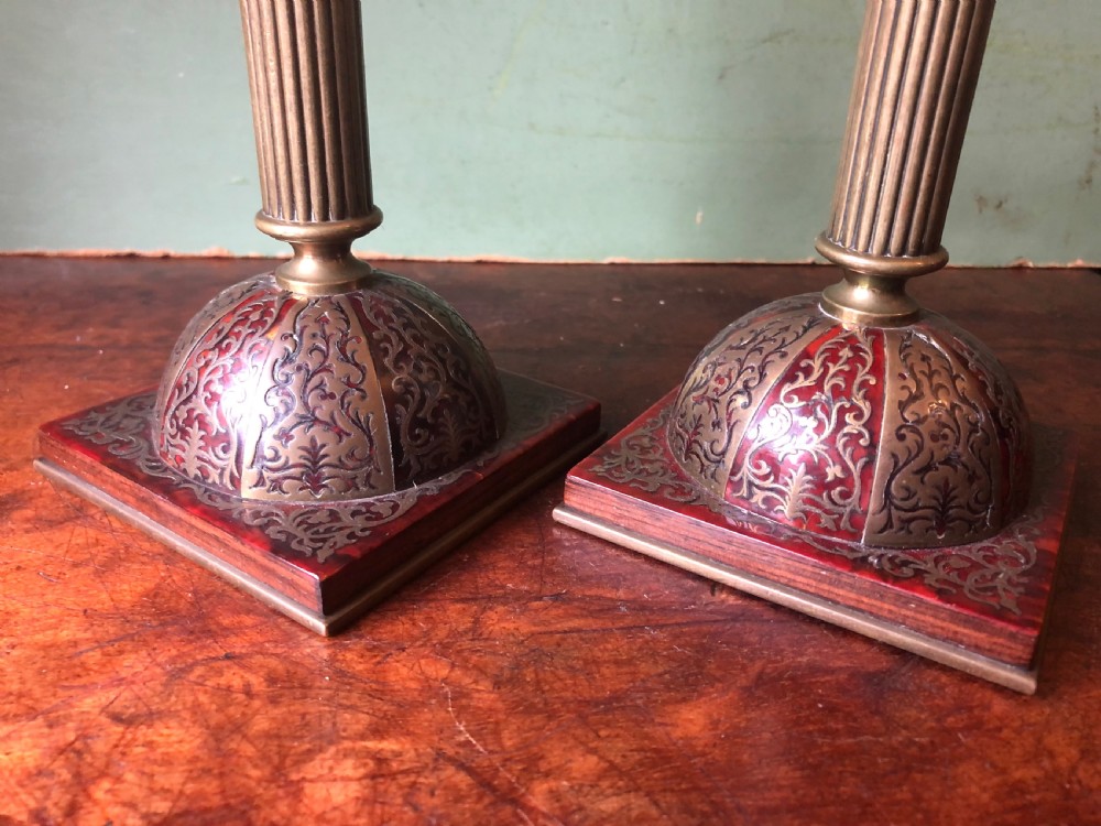 A pair of late 19th-century brass candlesticks featuring fluted columns supported by domed square bases inlaid with red tortoiseshell and engraved brass Boulle-work scroll motifs. View XII