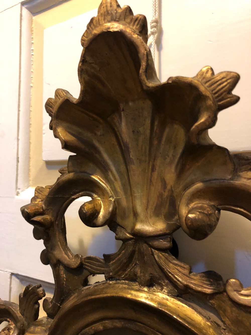 A pair of late eighteenth-century style carved giltwood pier mirrors featuring scrollwork cresting and shaped mirrored plates. View IV