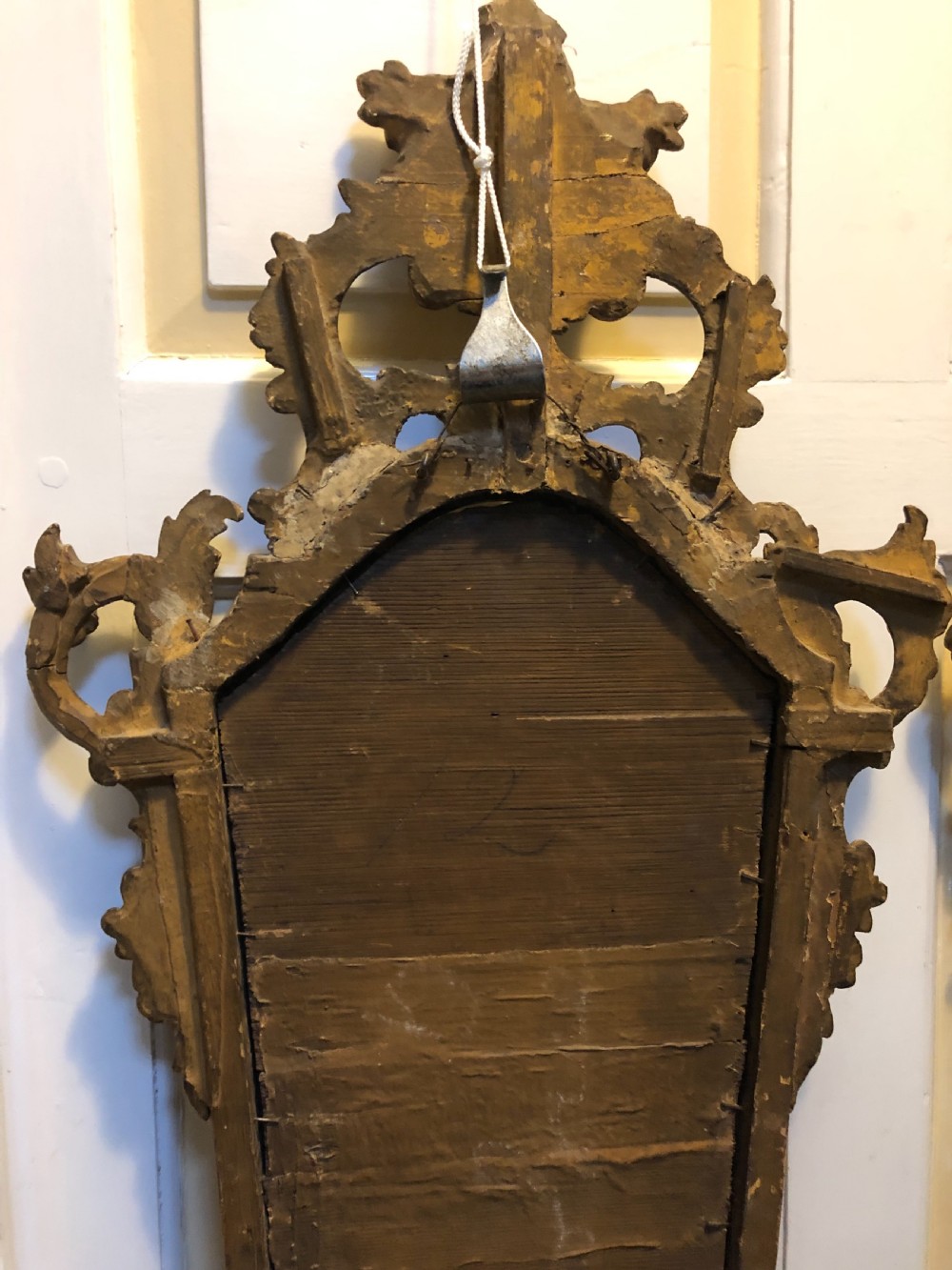 A pair of late eighteenth-century style carved giltwood pier mirrors featuring scrollwork cresting and shaped mirrored plates. View VI