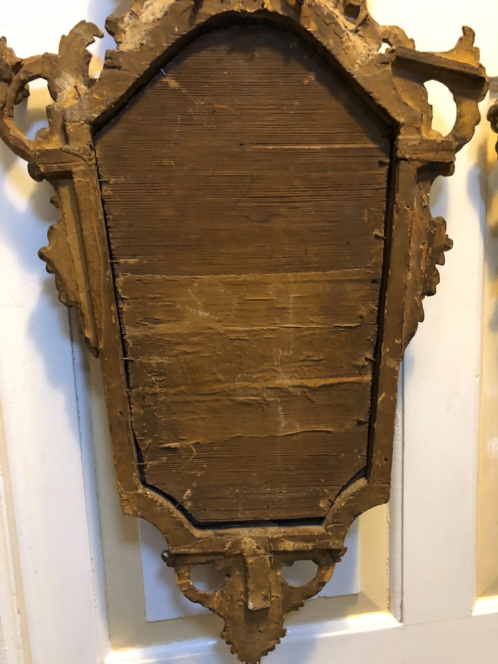 A pair of late eighteenth-century style carved giltwood pier mirrors featuring scrollwork cresting and shaped mirrored plates. View VII