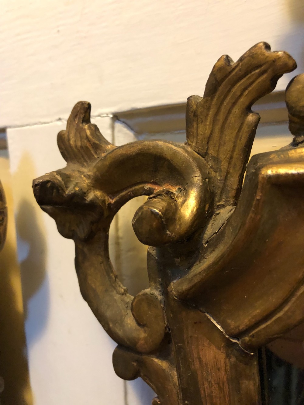 A pair of late eighteenth-century style carved giltwood pier mirrors featuring scrollwork cresting and shaped mirrored plates. View X