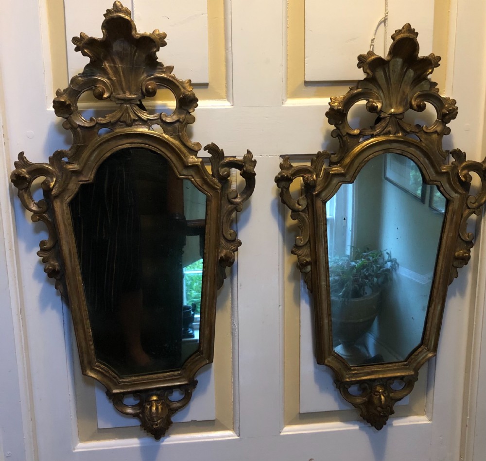 A pair of late eighteenth-century style carved giltwood pier mirrors featuring scrollwork cresting and shaped mirrored plates. View XIII