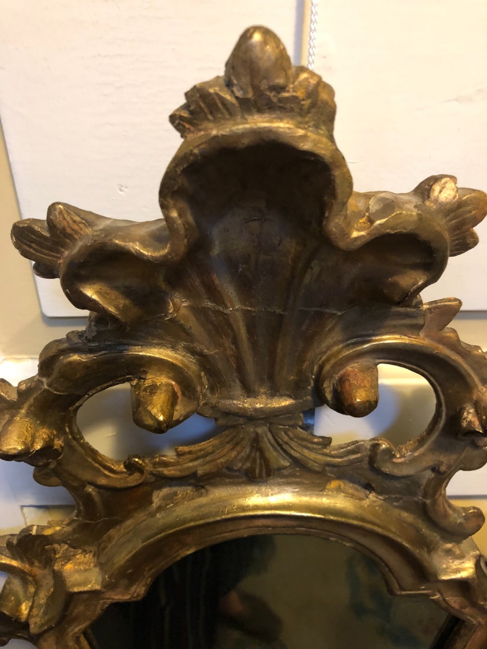 A pair of late eighteenth-century style carved giltwood pier mirrors featuring scrollwork cresting and shaped mirrored plates. View XIV