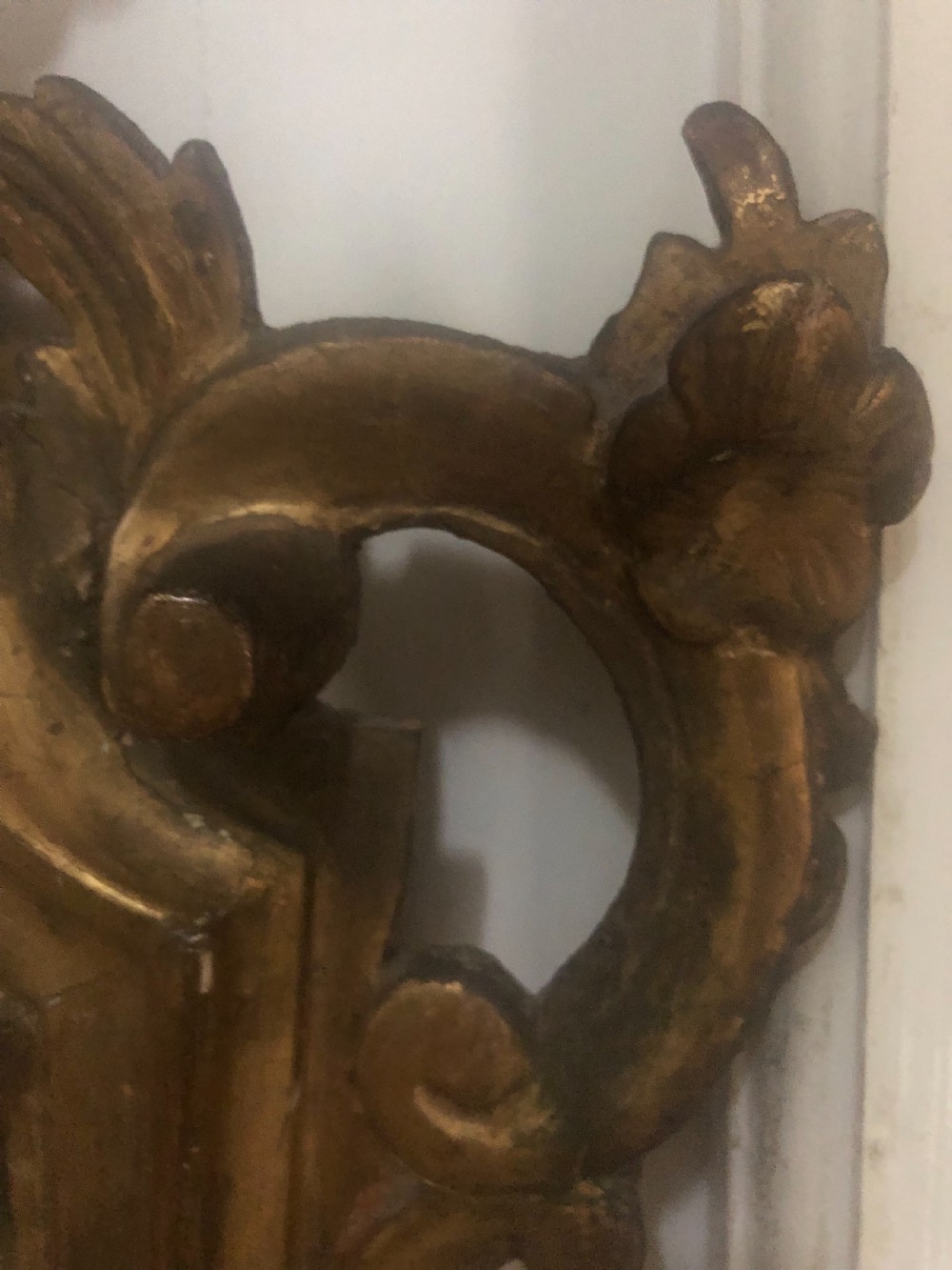 A pair of late eighteenth-century style carved giltwood pier mirrors featuring scrollwork cresting and shaped mirrored plates. View XVIII