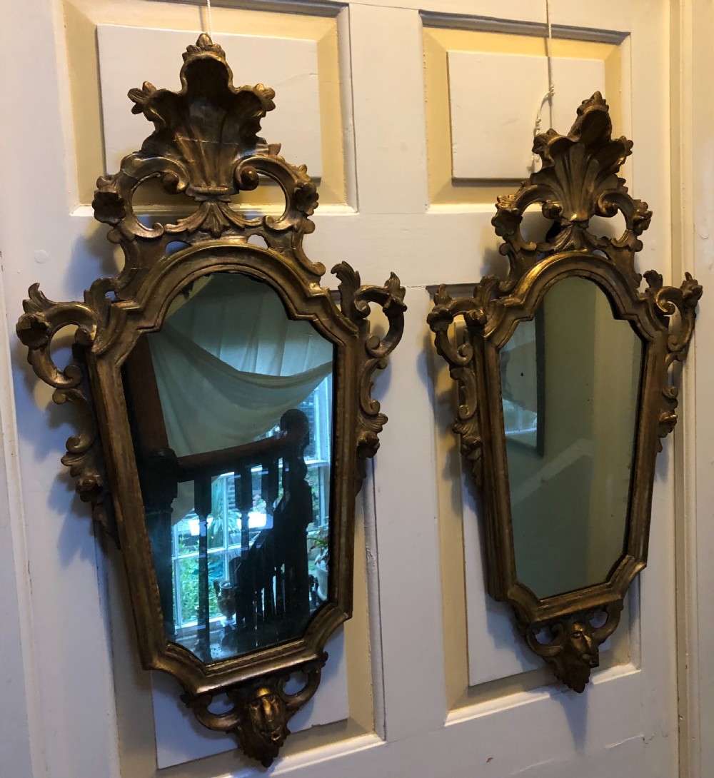 A pair of late eighteenth-century style carved giltwood pier mirrors featuring scrollwork cresting and shaped mirrored plates. View XXIV
