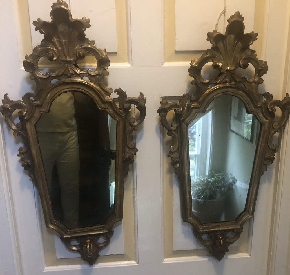 A pair of late eighteenth-century style carved giltwood pier mirrors featuring scrollwork cresting and shaped mirrored plates. View XI