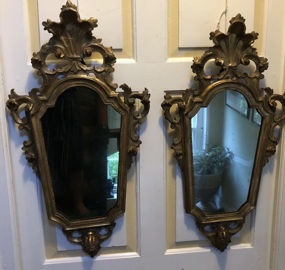 A pair of late eighteenth-century style carved giltwood pier mirrors featuring scrollwork cresting and shaped mirrored plates. View XXVI
