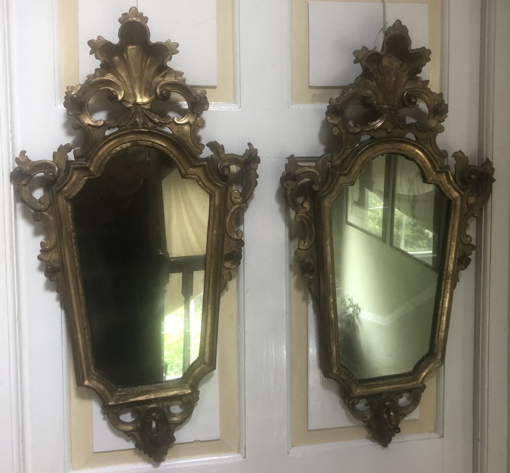 A pair of late eighteenth-century style carved giltwood pier mirrors featuring scrollwork cresting and shaped mirrored plates. View XV