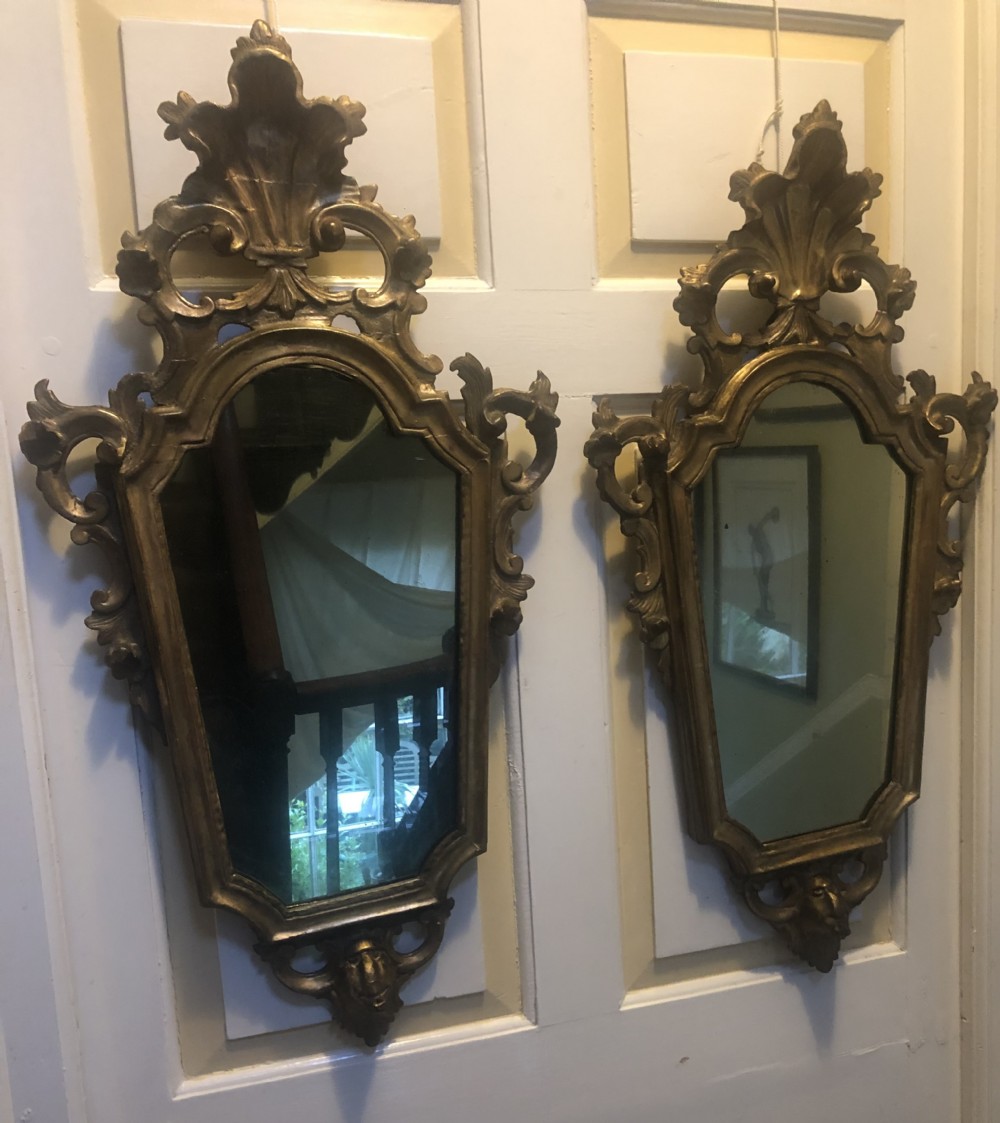 A pair of late eighteenth-century style carved giltwood pier mirrors featuring scrollwork cresting and shaped mirrored plates. View XXI