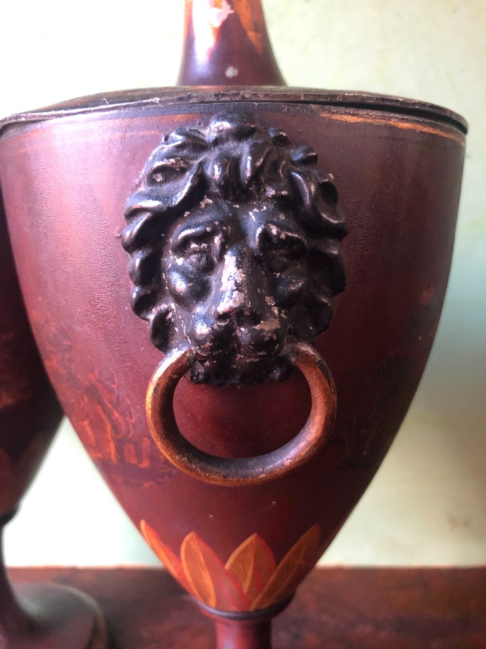 A pair of early 19th-century Dutch neoclassical chestnut urns in dark brown japanned pewter, painted with landscape scenes, leaf motifs, side ring handles, and tall finial lids. View VIII