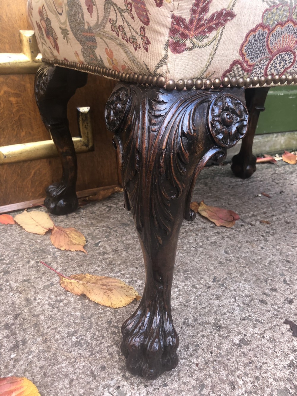 A rectangular floral upholstered stool featuring dark carved walnut cabriole legs with floral knees and claw-and-ball feet. View III