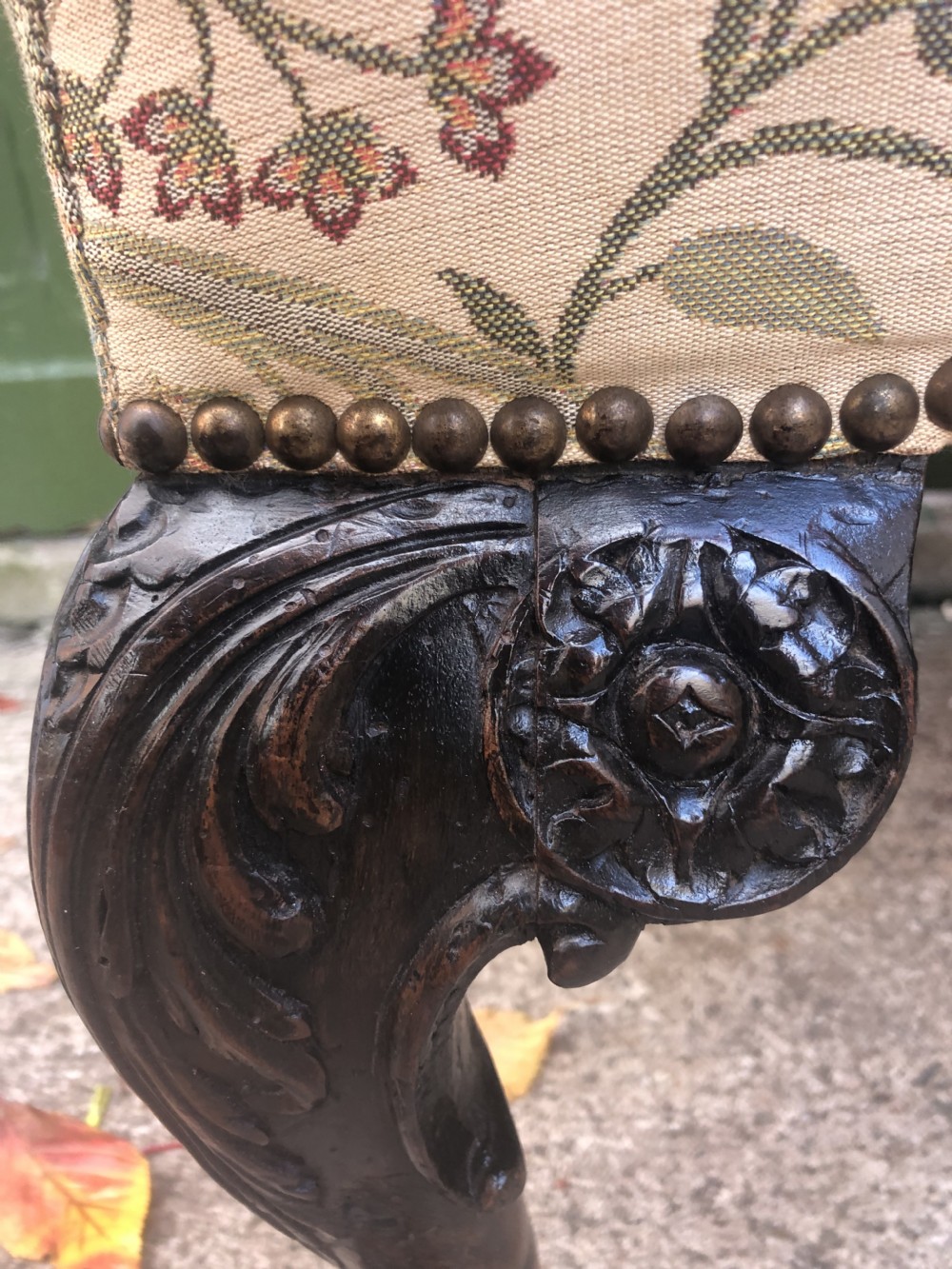 A rectangular floral upholstered stool featuring dark carved walnut cabriole legs with floral knees and claw-and-ball feet. View V