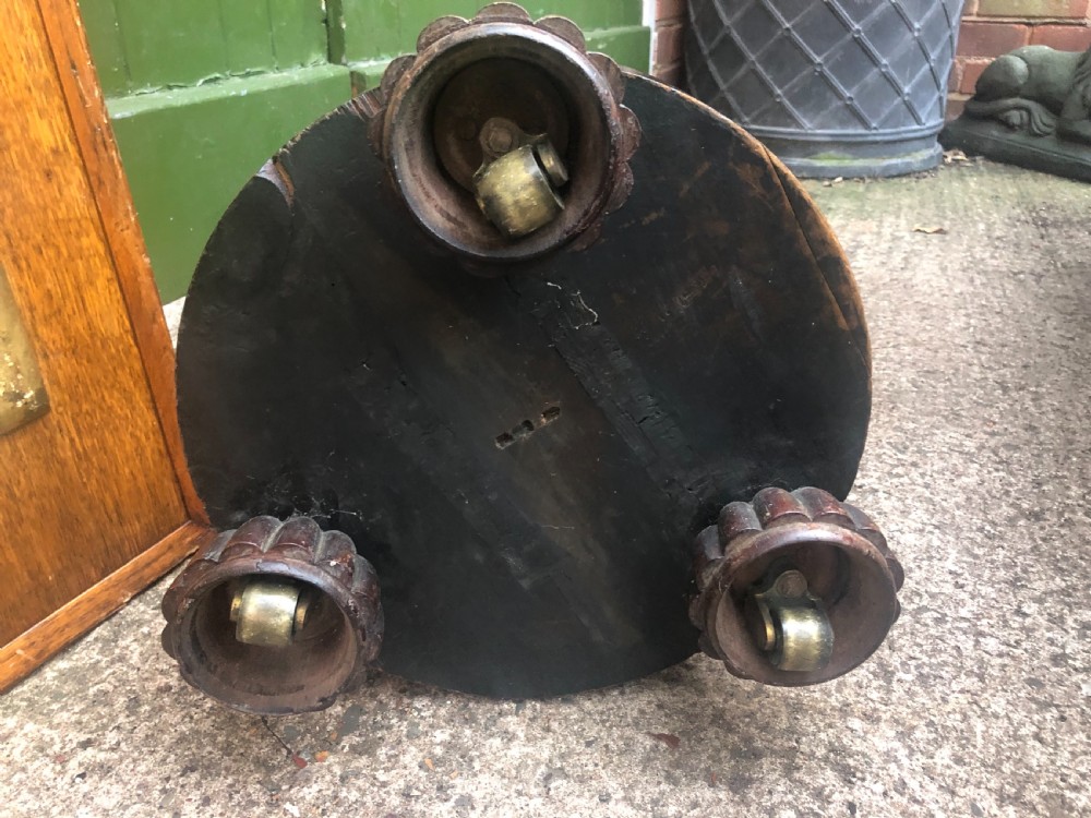 A dark brown turned rosewood columnar sculpture pedestal featuring a moulded top disc, architectural cylindrical shaft, and carved feet. View XIII
