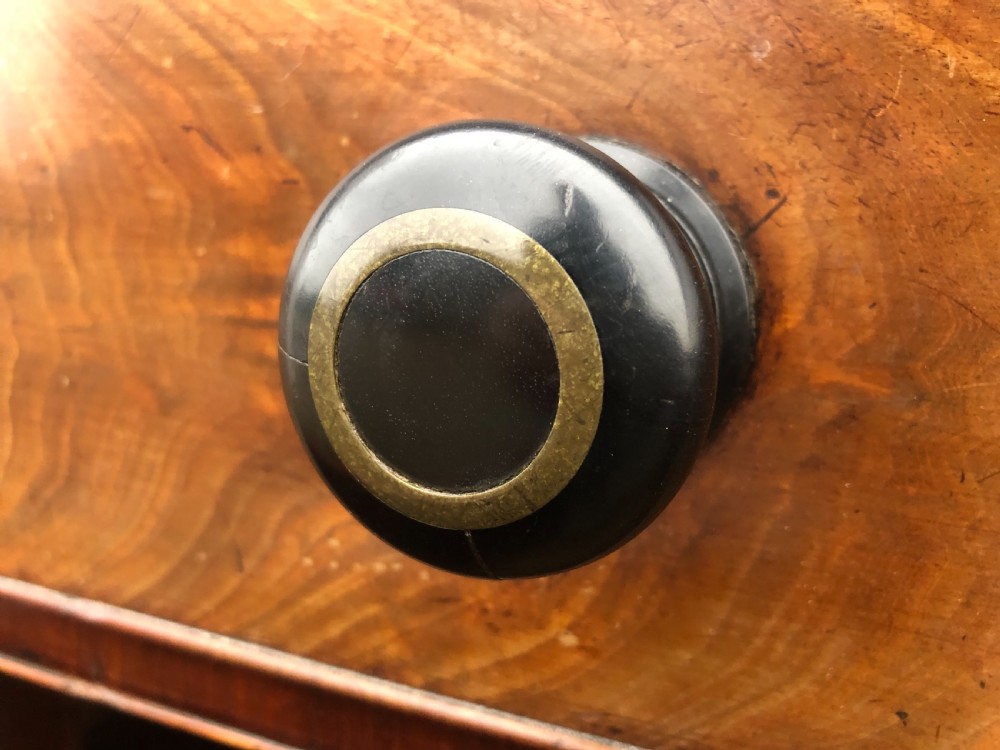 An early 19th-century William IV mahogany serving buffet featuring a carved scroll upstand, a top drawer with turned knobs, and twin panelled cupboard doors. View X