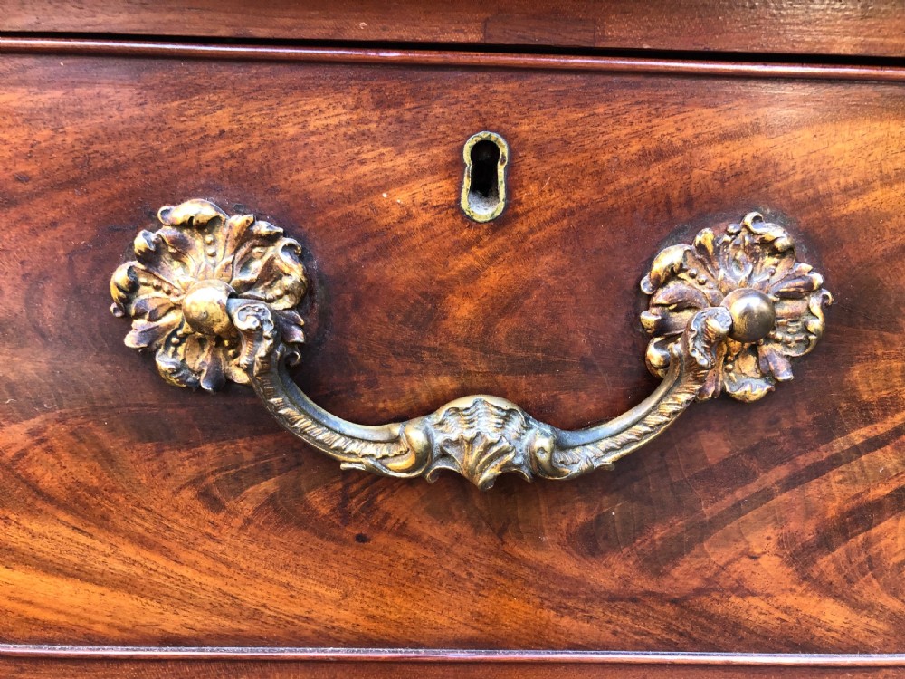 A William IV flame mahogany linen press featuring a double door upper cupboard with rope-twist side columns set above a lower chest of drawers with brass handles. View VII