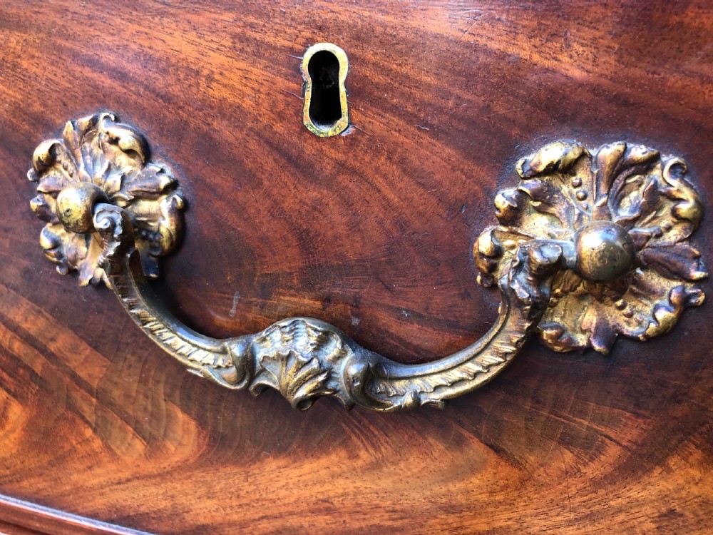 A William IV flame mahogany linen press featuring a double door upper cupboard with rope-twist side columns set above a lower chest of drawers with brass handles. View XII