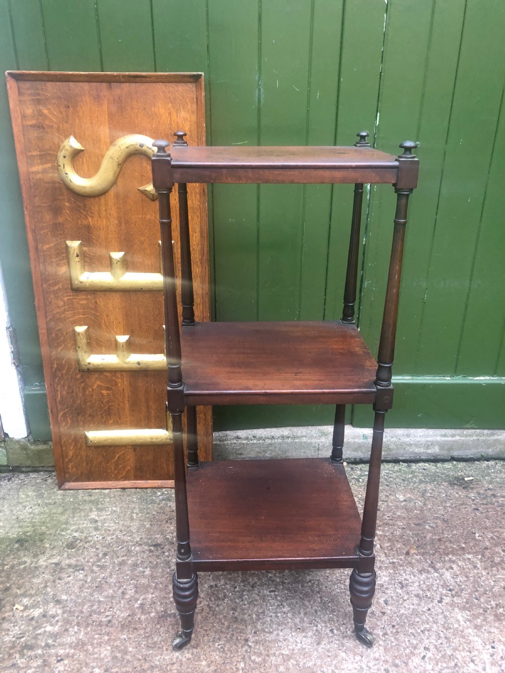 An early 19th-century George III mahogany three-tiered etagere with turned upright supports and brass castors.