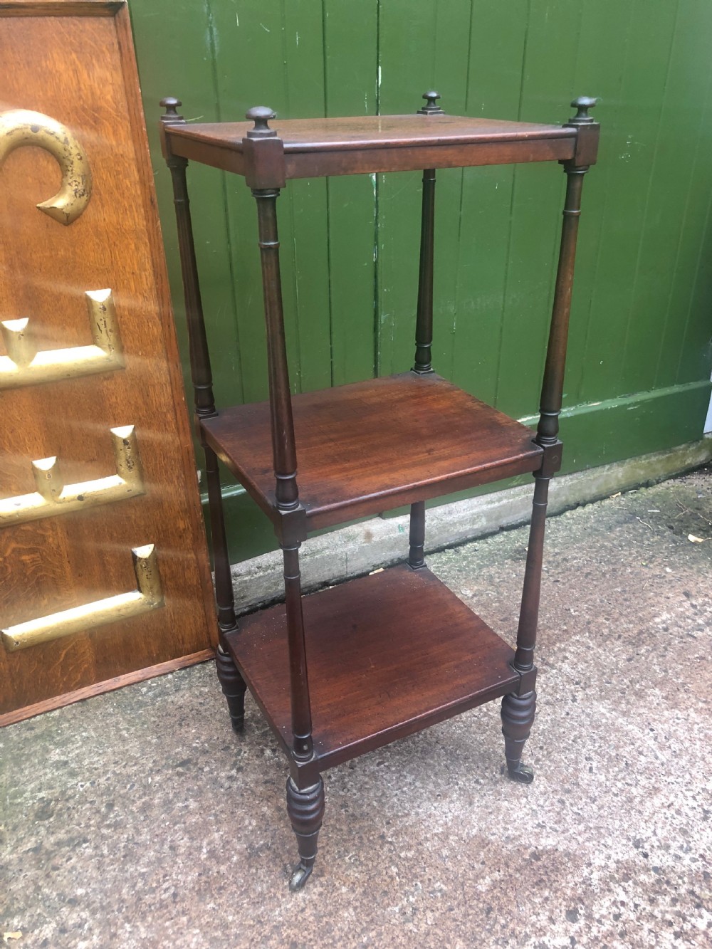 An early 19th-century George III mahogany three-tiered etagere with turned upright supports and brass castors. View II