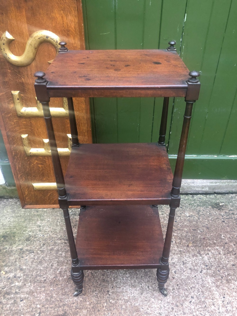 An early 19th-century George III mahogany three-tiered etagere with turned upright supports and brass castors. View III