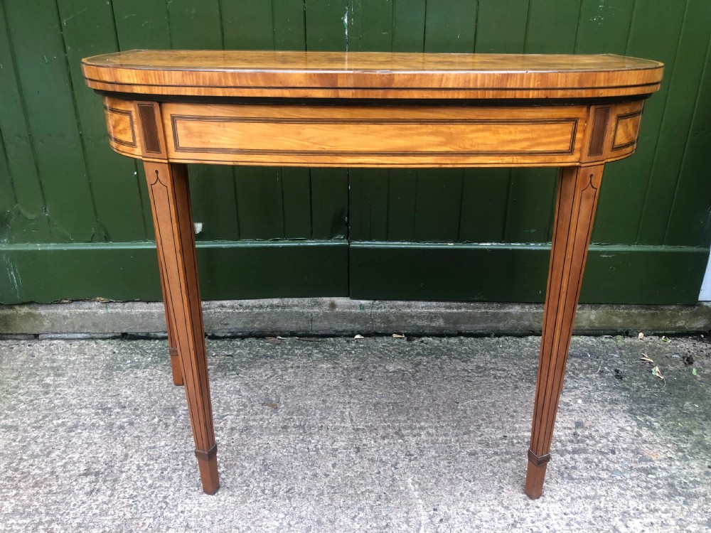 A late 18th-century George III satinwood fold-over card table featuring rosewood crossbanding, line inlay, and tapered square legs. View IX