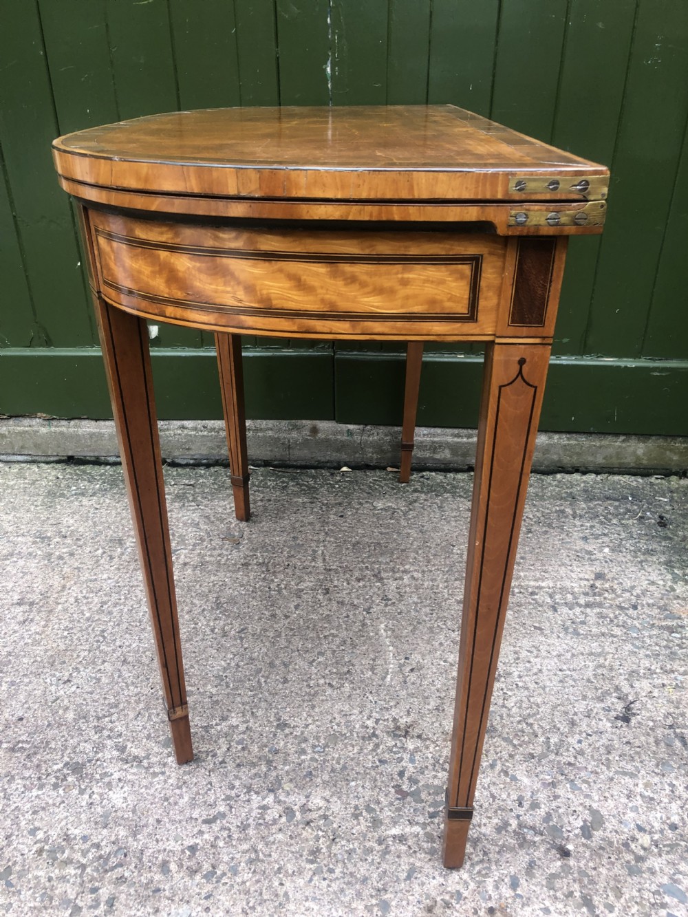 A late 18th-century George III satinwood fold-over card table featuring rosewood crossbanding, line inlay, and tapered square legs. View XVII