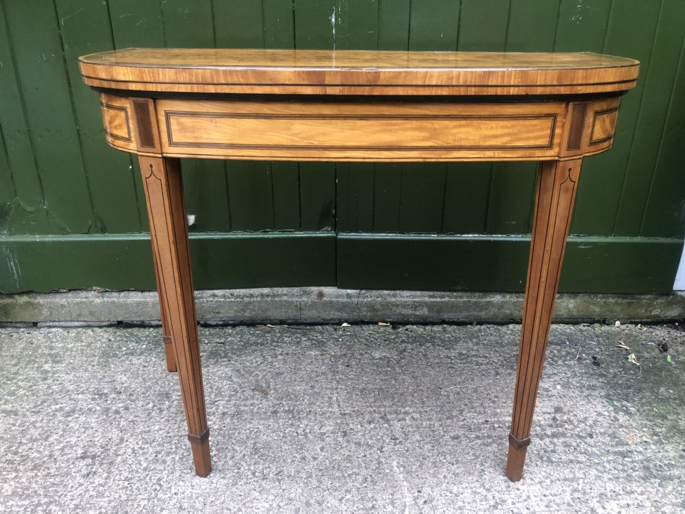A late 18th-century George III satinwood fold-over card table featuring rosewood crossbanding, line inlay, and tapered square legs. View XVIII