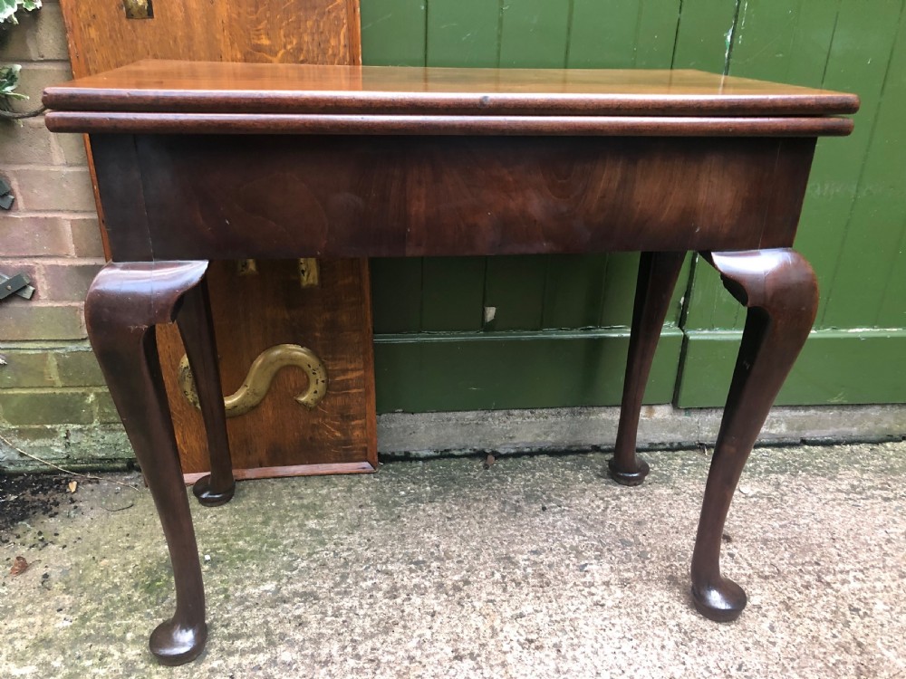 A mid-18th-century George II mahogany fold-over gaming table featuring elegant cabriole legs with pad feet. View X