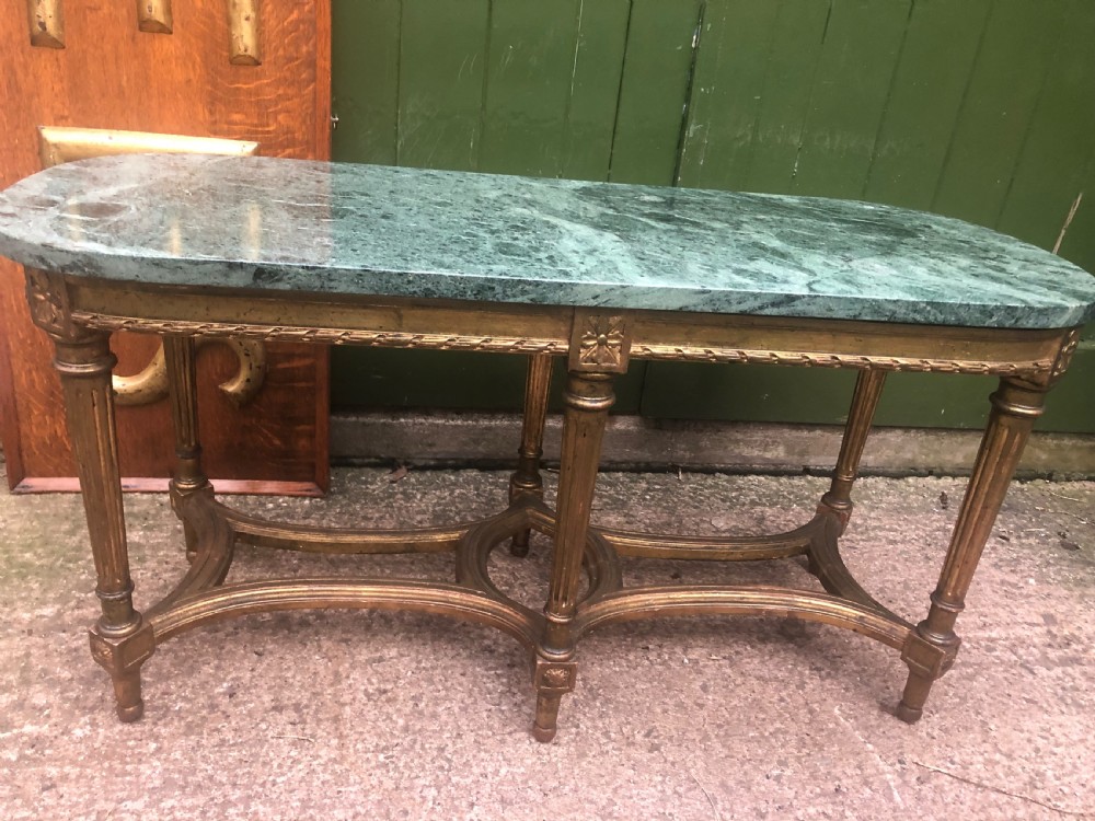 An early 20th-century French Louis XVI style low table with a green marble top, giltwood frame, fluted legs, and carved rosette details. View II