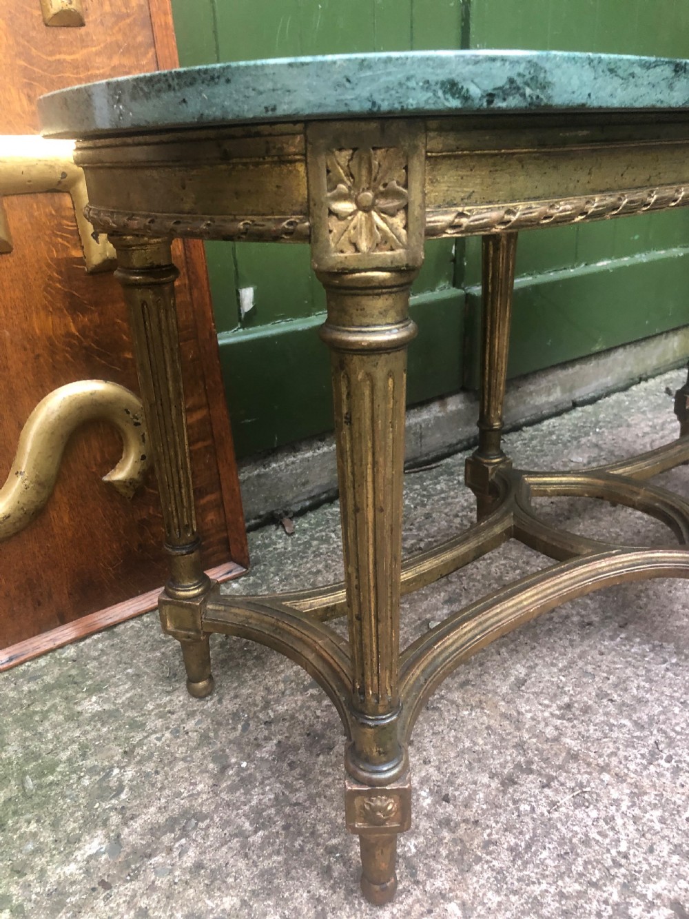 An early 20th-century French Louis XVI style low table with a green marble top, giltwood frame, fluted legs, and carved rosette details. View III