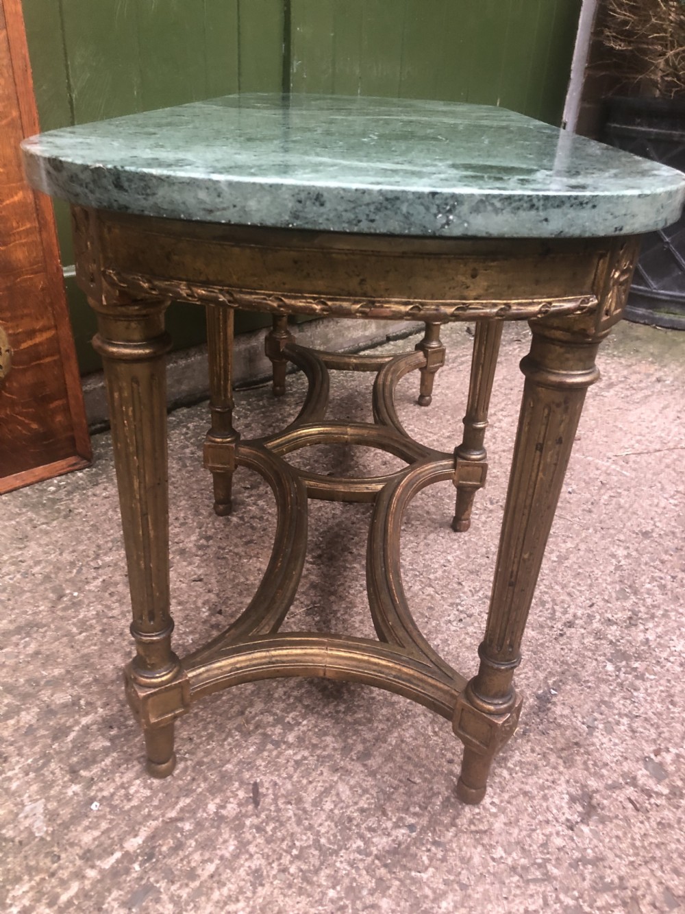 An early 20th-century French Louis XVI style low table with a green marble top, giltwood frame, fluted legs, and carved rosette details. View VI