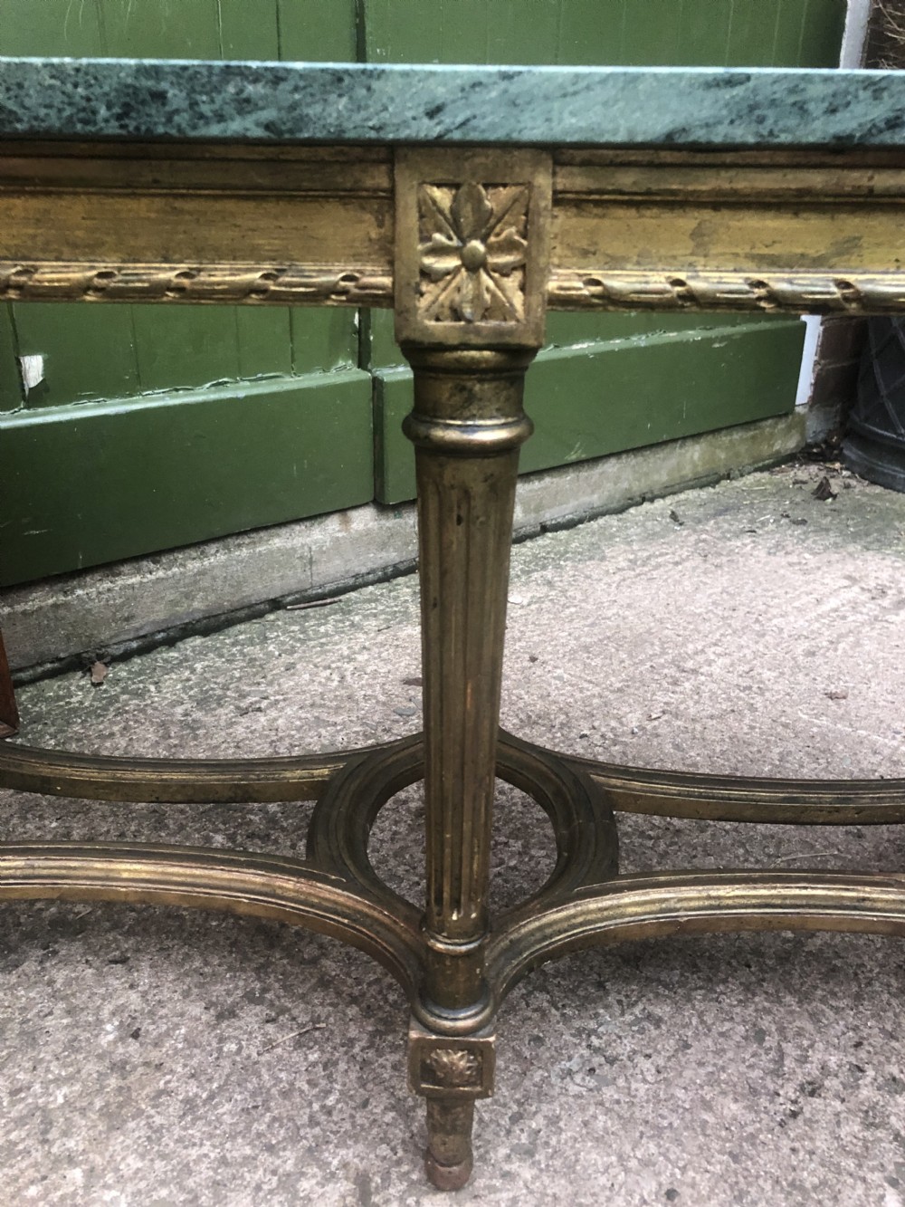 An early 20th-century French Louis XVI style low table with a green marble top, giltwood frame, fluted legs, and carved rosette details. View XI