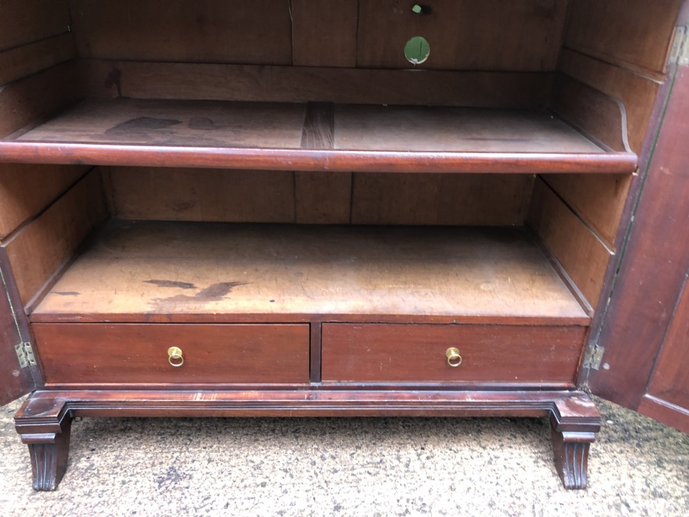 An early nineteenth-century flame mahogany side cabinet with arch-panelled double doors, top drawer, and brass fittings. View VIII