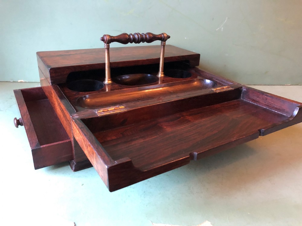 A dark rosewood rectangular desk tidy featuring a central turned wood and brass handle, hinged lids, and a moulded base. View III