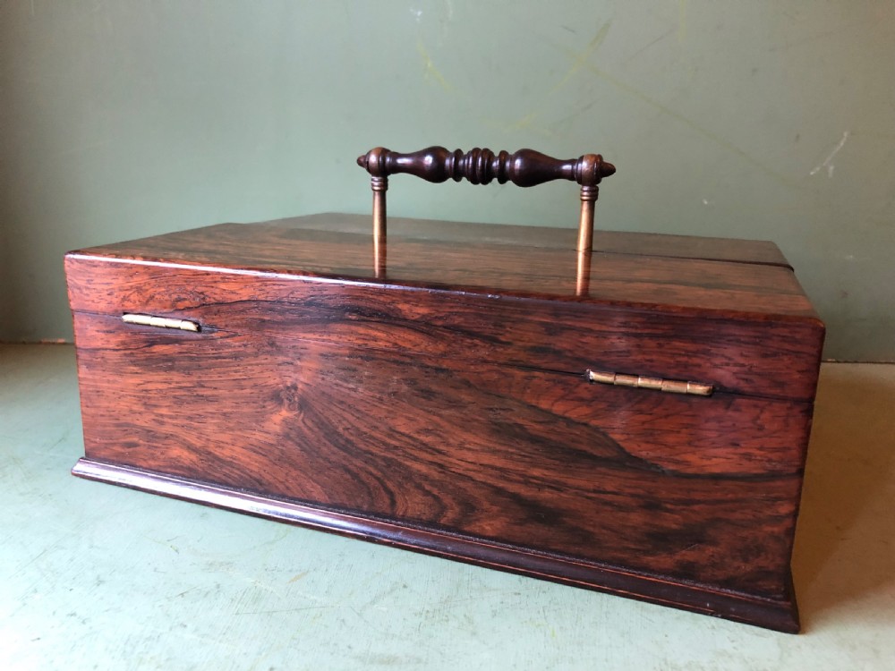 A dark rosewood rectangular desk tidy featuring a central turned wood and brass handle, hinged lids, and a moulded base. View V