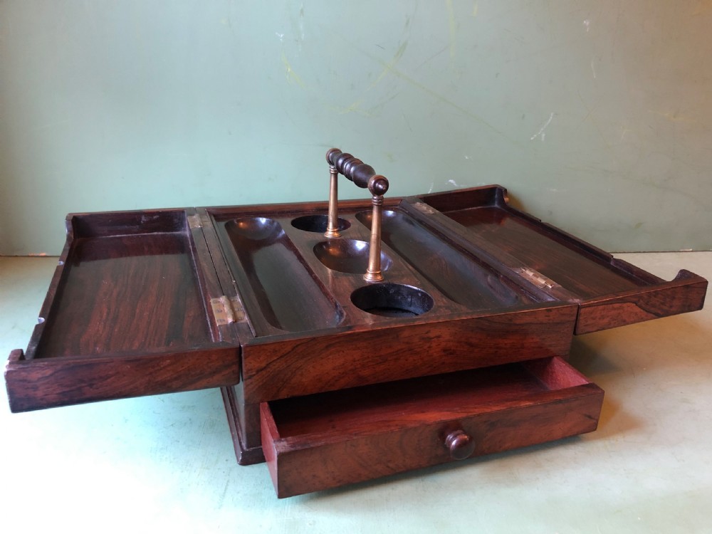 A dark rosewood rectangular desk tidy featuring a central turned wood and brass handle, hinged lids, and a moulded base. View VI