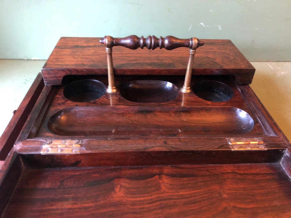 A dark rosewood rectangular desk tidy featuring a central turned wood and brass handle, hinged lids, and a moulded base. View VII