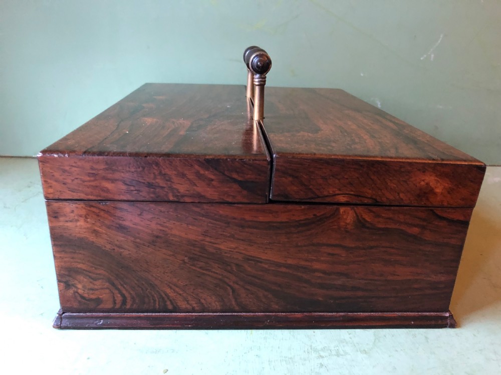 A dark rosewood rectangular desk tidy featuring a central turned wood and brass handle, hinged lids, and a moulded base. View VIII