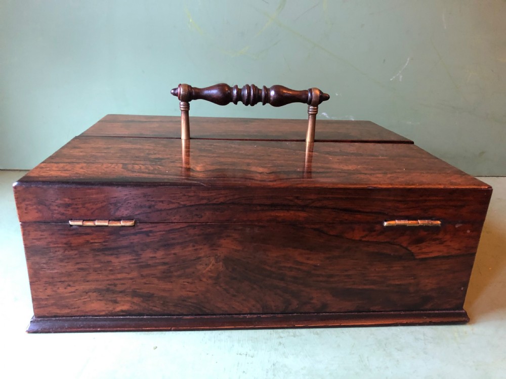 A dark rosewood rectangular desk tidy featuring a central turned wood and brass handle, hinged lids, and a moulded base. View IX