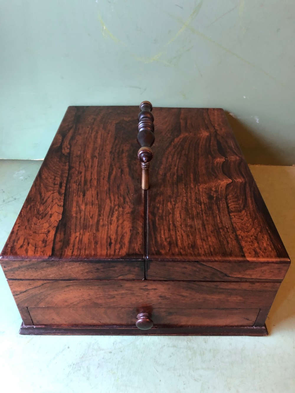 A dark rosewood rectangular desk tidy featuring a central turned wood and brass handle, hinged lids, and a moulded base. View XII
