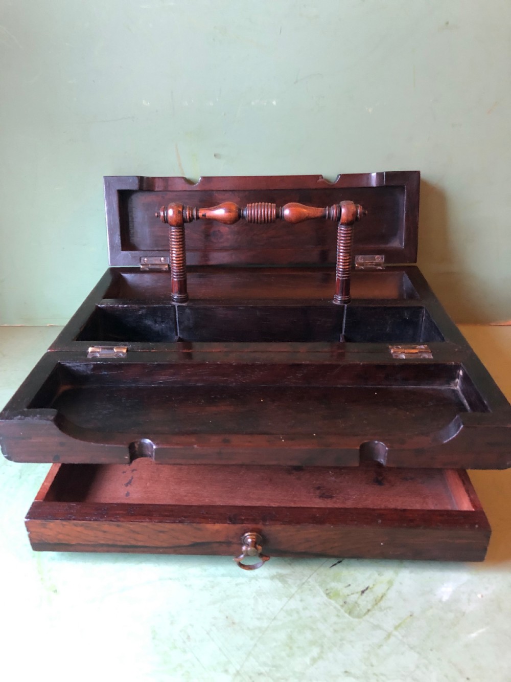 A dark rosewood rectangular desk tidy featuring a central turned wood and brass handle, hinged lids, and a moulded base. View XVIII